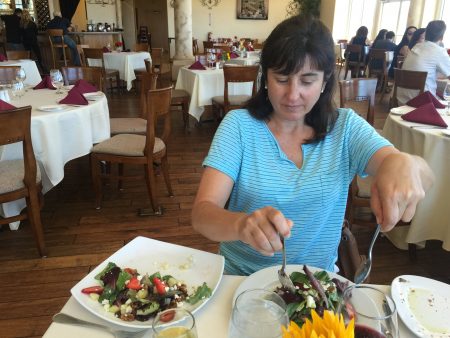 Cyndy attacks the salad carefully dividing the contents